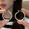 Silver textured circle hoop earrings with faceted design held by hand in soft focus - Faceted Texture Mirror Style (E2042 Silver) / 925 Silver Needle / Silver