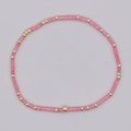 Pulsera boho hecha a mano con columnas rosas y cuentas doradas en una exhibición circular - Cuentas Rosa Oro