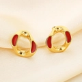 Macro shot of gold geometric earrings with red enamel on a silk background - Irregular Hoop Style (KE114510-K)