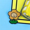 Graziosa spilla a fiore arancione in smalto con viso cartoon su sfondo blu e giallo - Fiorellino