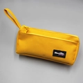 Detail of bright yellow canvas pencil case with zipper and Almost Blue woven label - Yellow