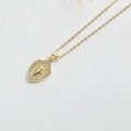 Macro shot of gold heart pendant with Virgin Mary relief and white zircons on leather - Shield Shape Virgin Mary