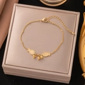 Goldenes Titanstahl-Armband mit kleinen Fisch-Anhängern und Perlen auf einer Schmuckbox - Doppelfisch-Stil (B5005)