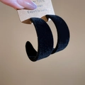 Vue rapprochée de grandes boucles d'oreilles en C noires avec texture en velours - Noir
