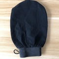 Close-up of black exfoliating Moroccan bath mitt with textured sand surface and hanging loop - Premium Black