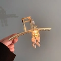 Detailopname van gouden vintage haarspeld met een lichtgevende lantaarn en parelkwastjes - Haarklem Stijl / Gouden Gloeiende Lantaarn Haarklem