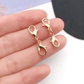 Close-up of two small gold-plated double-ended lobster clasps for DIY jewelry making - KC Gold