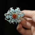 Detail of blue enamel flower hair clip with gold filigree and central red bead inlay - F1457 Flower