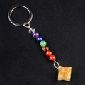 Seven chakra natural stone keychain with yellow star-shaped crystal pendant on black background - Yellow Jade
