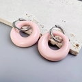 Close-up of pink resin oval hoop earrings with silver stainless steel clasp on stone - Steel-Pink