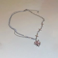 Macro detail van zilveren dubbele ketting met roze hart edelsteen en stervormige schakels - Roze Hart Ster Stijl