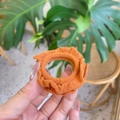 Close-up of orange ruffled fabric hair scrunchie showing detailed pleated texture - Turmeric