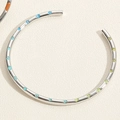 Détail d'un bracelet argenté avec fleurs en émail coloré et motifs de cœur sur papier - Bracelet Fleur en Émail Style (SL0194-5)