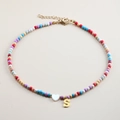 Detail of colorful beaded necklace with white heart pendant and golden letter S charm - Letter S