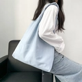 Detailed lifestyle shot of blue canvas tote bag with white polka dots on a shoulder - Small Polka Dots Blue