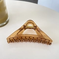 Macro shot of 12cm translucent amber triangular hair claw clip with golden metal spring - Transparent Coffee