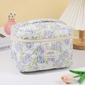Dettaglio della borsa da trucco trapuntata in cotone a fiori con manico e cerniera - Fiore Blu