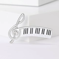Dettaglio macro di spilla chiave di violino argento con smalto a tastiera di piano - Argento