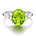 Oval cut green peridot ring with white side stones in polished silver setting - Peridot Green