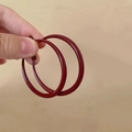 Macro shot of large burgundy red enamel hoop earrings held by hand for scale - 5# 925 Sterling Silver Earring Post - Red - 3.9cm Diameter Painted Hoop