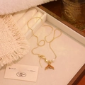 Detailed shot of golden fishtail necklace with colorful stones and pearl in jewelry box - Orange & Yellow