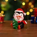 Resin Christmas penguin figurine wearing a red hat and holding a small green tree - Small Penguin