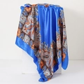 Blue satin silk scarf with orange paisley print draped over a white cube base - 90*90cm / Sapphire Blue