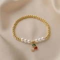 Détail du bracelet perlé doré avec pendentif cerise en cristal sur fond de satin - E000418YS-Cerise Gemme Trois Couleurs