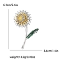 Silver dandelion flower brooch with golden center and green leaves showing 6.1cm height - Silver