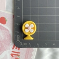 Gros plan d'un mini ventilateur en résine de 2cm jaune et blanc sur tapis gradué - Ventilateur