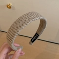Détail du bandeau en maille beige tressé à la main montrant la texture et l'étiquette - Serre-tête Tricoté / Kaki