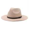 Detailed close-up of straw hat weave with black leather band and gold metal studs - Beige