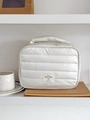 Detail of white quilted nylon makeup bag with pearlescent finish and carry handle - White