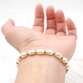 Verstellbares Süßwasserperlen-Armband mit Goldperlen für Damen auf weißem Grund - Barockperle