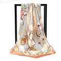 Detailed close-up of a satin silk scarf featuring horse carriage and paisley patterns - Orange Edge Beige Carriage (016)