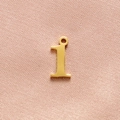 Polished gold-plated number 1 pendant detail for DIY jewelry on pink fabric background - Gold Number 1