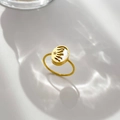 Dettaglio di un anello dorato con base in madreperla e design a sole traforato unico - Sole Zirconia