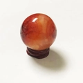 Polished red agate crystal ball with natural textures on a round wooden base - Red Agate Ball