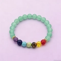 Adjustable woven bracelet with light green beads and seven chakra stones in a flat lay view - Light Green Aventurine with 7 Chakra Elastic Bracelet - jw30