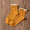 Ginger yellow knit crew socks with white lace trim and pearls on dark wood - One Size / Ginger Yellow