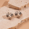 Detail silberner geometrischer C-Ohrringe mit Schichtstruktur auf Naturstein - Silber (Silberstift) / Silber