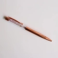 Detail view of a rose gold metal ballpoint pen filled with pink crystal gravel - Kunzite
