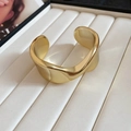 Dettaglio di un bracciale rigido dorato largo con superficie ondulata lucida irregolare - Stile a Onda Irregolare / 1# Bracciale-Oro