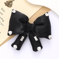 Detail of black satin bow with sparkling rhinestones on vintage stationery background - Black