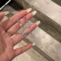Silver butterfly tassel earrings with sparkling crystals and drop pearls on hand - Silver Butterfly Pearl Tassel Earring Post (A1781)