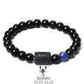 Macro shot of Scorpio zodiac bead on obsidian and tiger eye beaded stretch bracelet - Scorpio