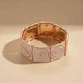 Detailansicht des Vintage-Emaille-Armbands mit goldenem Spiralmuster und Quadraten - Beige