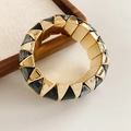 Close-up of wide stretch bracelet with gold metal triangles and black marble resin - Black
