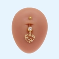 Gros plan piercing nombril doré avec pendentifs cœur, étoile et lune sertis - Style Coeur Ajouré Étoile Lune