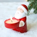 Christmas Santa Claus candle holder with a burning candle on a snowy background - Santa Claus